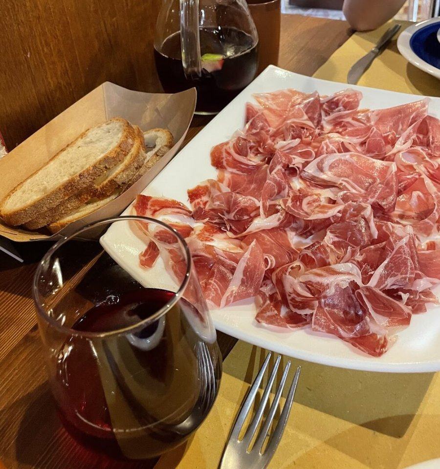 Piatto di jamón ibérico con pane e una caraffa di sangria rossa